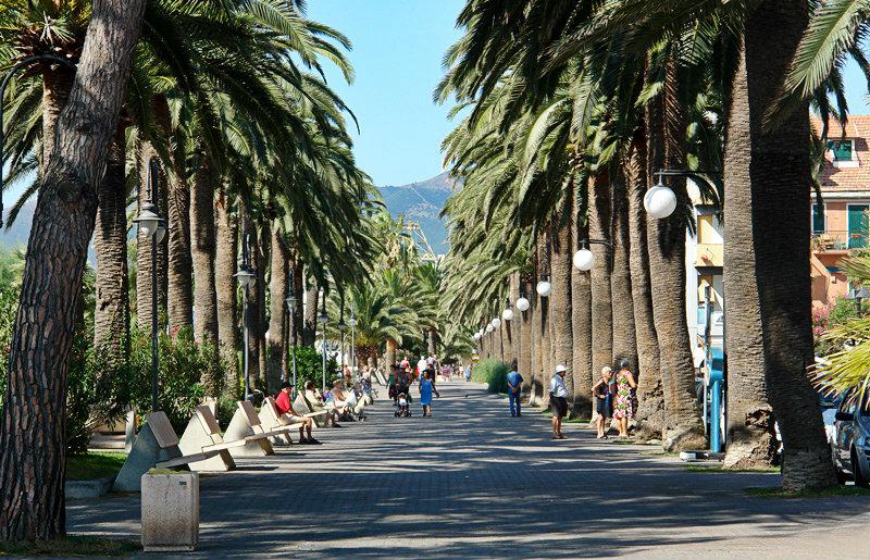 Een straat met palmbomen in Pietra Ligure
