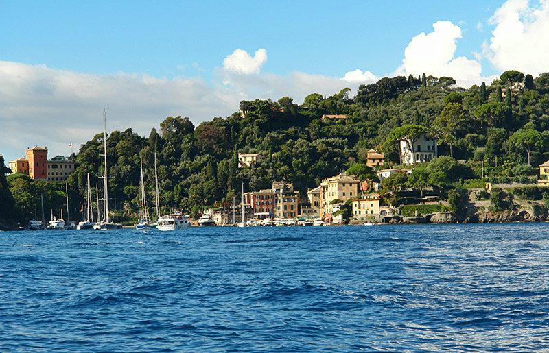 De heldere blauwe zee en huizen in Portofino