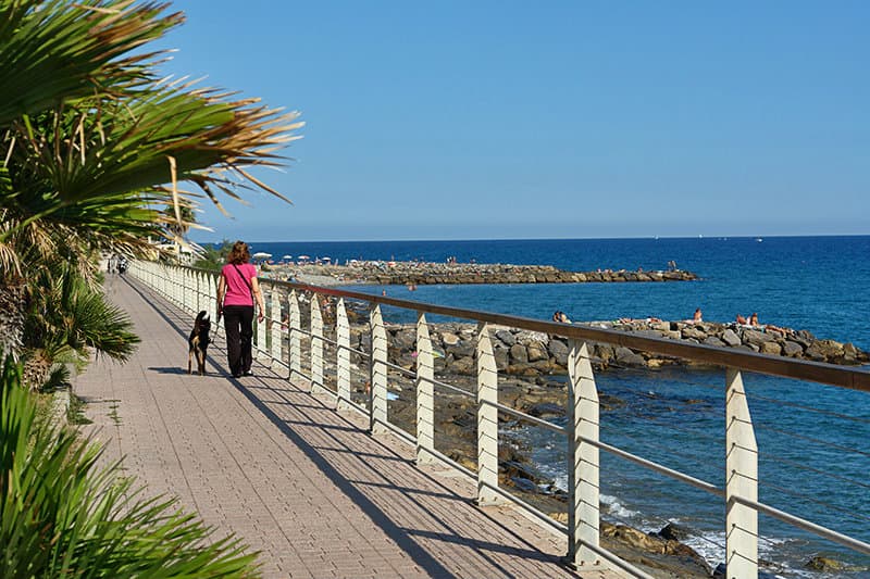 Een vrouw loopt langs de kust in Riva Ligure