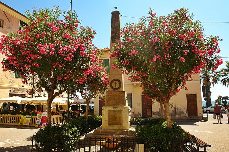 Een oude sculptuur en bloemen in Riva Ligure